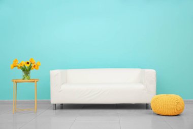 Beyaz kanepe, masa ve Osmanlı renk duvarının yakınında