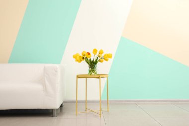 Beyaz kanepe ve vazo çiçek renk duvarının yakınında olan tablo