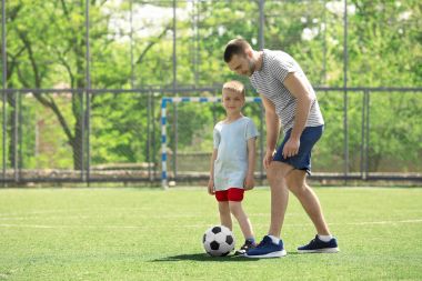 Baba oğul futbol oynuyor.  