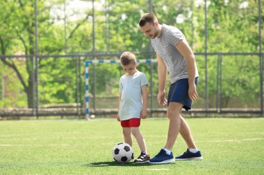 Baba oğul futbol oynuyor.  