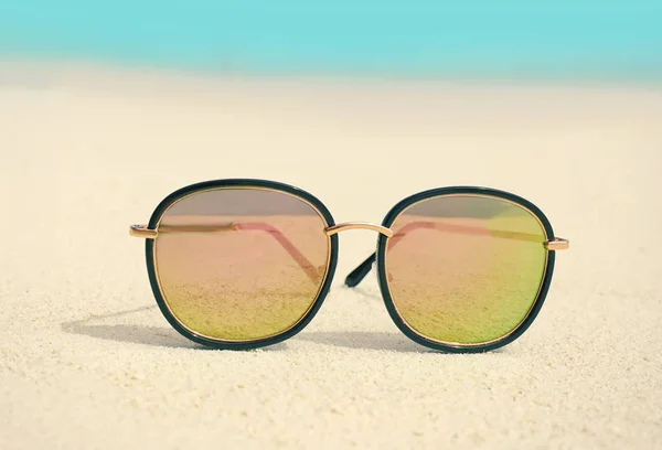 Modern sunglasses on beach sand — Stock Photo, Image