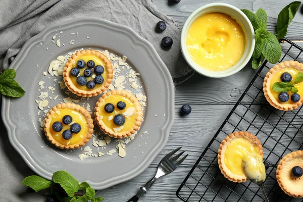 Leckere knusprige Torten mit Blaubeeren und Puddingcreme auf dem Tisch — Stockfoto