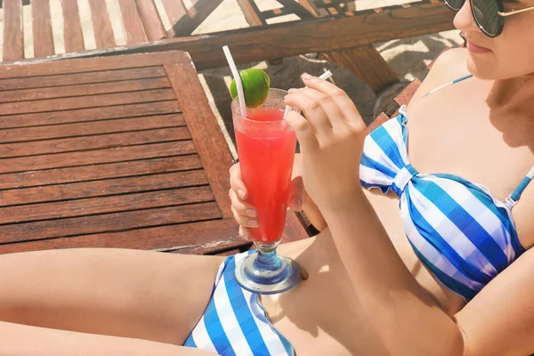 Vacker ung kvinna med cocktail på strand vid havet — Stockfoto