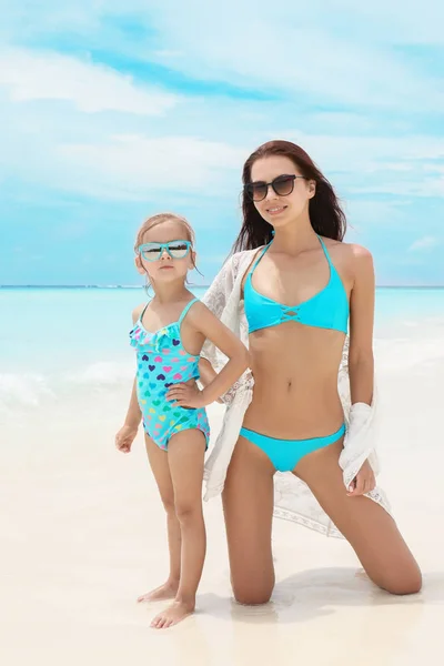 Schattig klein meisje met moeder op zee strand — Stockfoto
