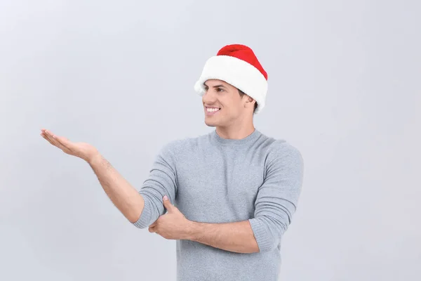 Bello uomo in cappello di Natale su sfondo chiaro — Foto Stock