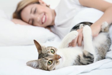 Evde yatakta yatarken kedi olan güzel kadın