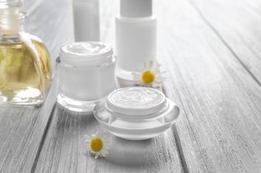 Krem ve papatya çiçekler ile cam kavanozlar 