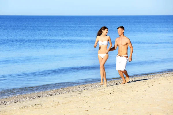 Счастливая молодая пара на морском пляже — стоковое фото