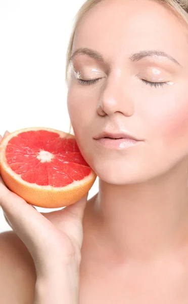 Молодая женщина позирует с половиной грейпфрута изолированы на белом — стоковое фото