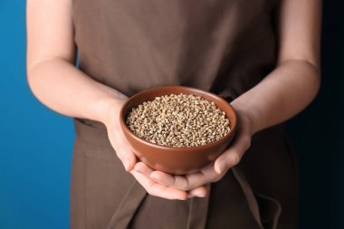 Kenevir tohumu ile genç bir kadın tutarak kase 