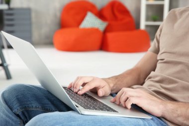 Genç adam dizüstü bilgisayar kullanıyor 