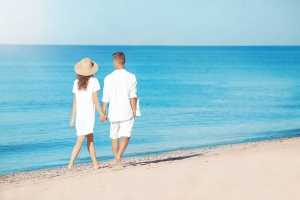 Молодая пара прогуливаясь по морскому пляжу — стоковое фото