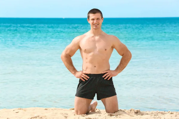 Bello giovane uomo sulla spiaggia di mare — Foto Stock