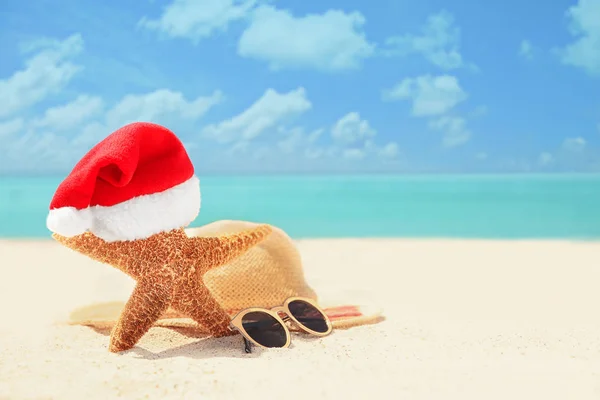 Composição com chapéu de Santa na praia — Fotografia de Stock