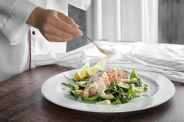 Chef versando salsa sul salmone — Foto Stock