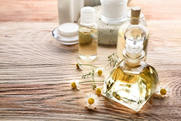 Bottle with essential oil and chamomile flowers — Stock Photo, Image
