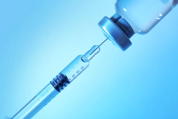 Syringe and medicine on blue — Stock Photo, Image