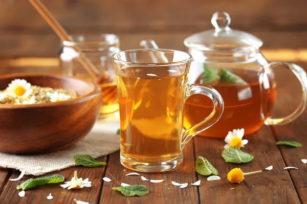 Šálek heřmánkového čaje na dřevěném stole — Stock fotografie