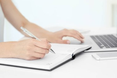 not defterinde yazılı ve dizüstü kullanan kadın