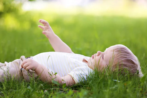 Bayi laki-laki lucu berbaring di rumput hijau — Stok Foto