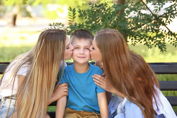 Gelukkig lesbische moeders kussen foster zoon in park. Aanneming concept — Stockfoto