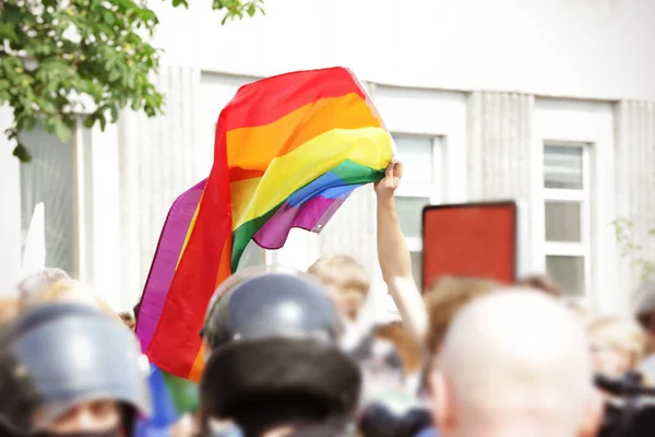 Hombre sosteniendo bandera de arco iris — Foto de Stock