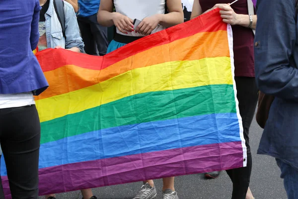 Gente sosteniendo bandera arco iris gay — Foto de Stock
