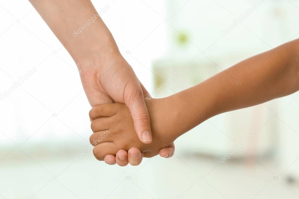 Woman holding hand of child