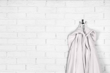 Tuğla duvara asılı bornoz