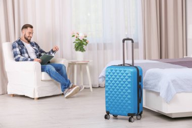 Genç adam dergi okuyor. 