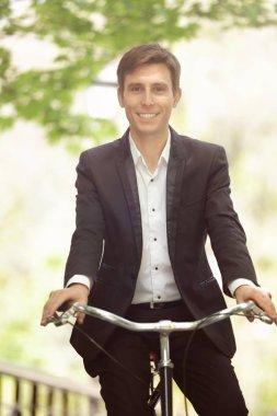 Genç yakışıklı işadamı güneşli günü açık havada bisiklet ile