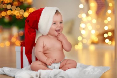 Bulanık Noel ışıkları karşı katta oturan Santa şapka içinde şirin bebek