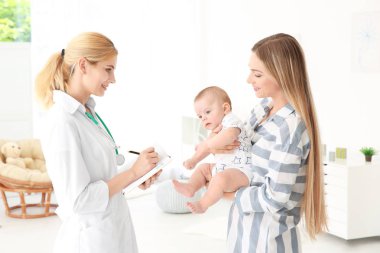 Doktor bir şey defter ve bebek evde annesiyle yazma