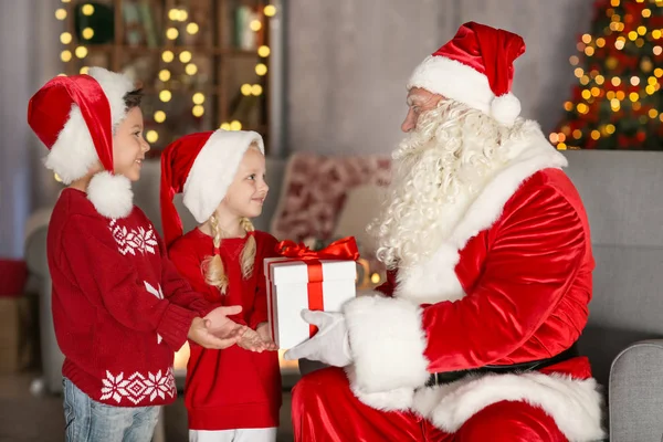 Jultomten att ge till barn i rum med vackra juldekorationer — Stockfoto