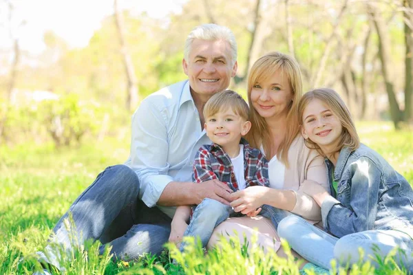 Cute happy children with grandparents in spring park on sunny day — Stock Photo, Image