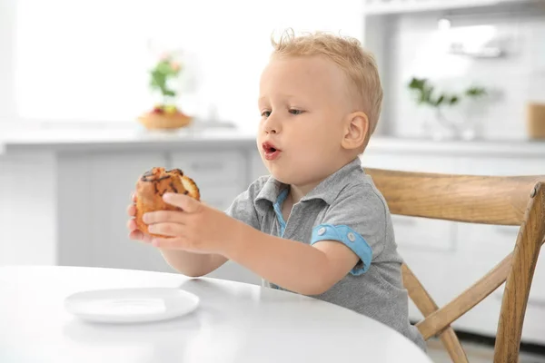 Adorabile bambino con in mano un grande muffin — Foto Stock