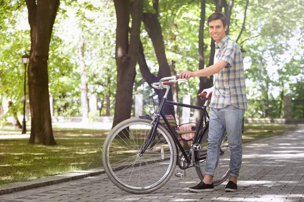 Jeune homme beau avec vélo à l'extérieur le jour ensoleillé — Photo