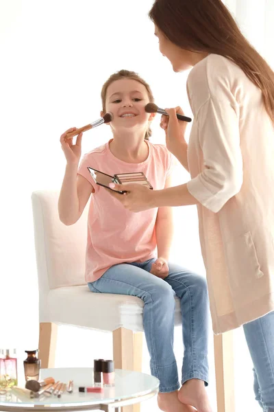 Женщина и дочь наносят макияж — стоковое фото