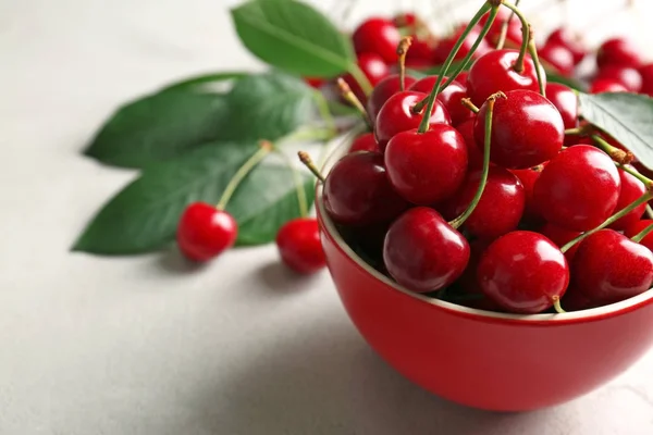 Ripe cherries in red ceramic bowl — Stock Photo, Image