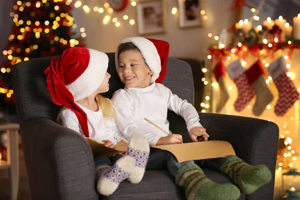 Bambini carini con lettere a Babbo Natale in camera decorata per Natale — Foto Stock