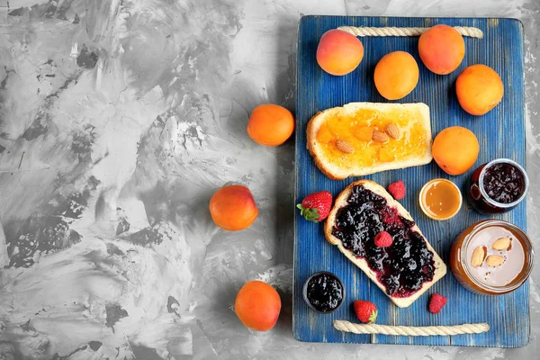 Slices of bread with apricot and berry jams — Stock Photo, Image