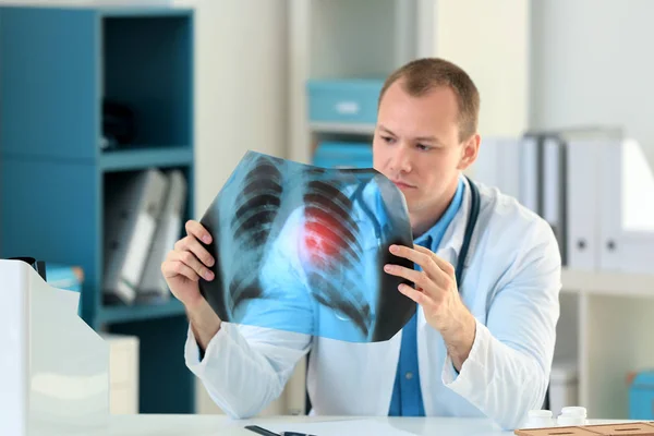 Doctor con imagen de rayos X en la mesa del hospital. Concepto de cáncer de pulmón — Foto de Stock