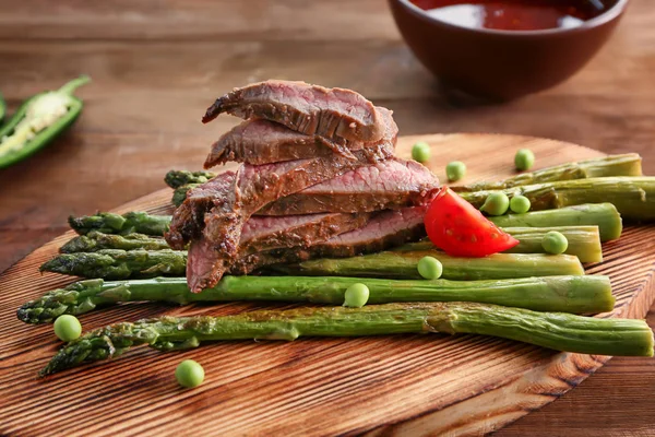 Sliced steak served with asparagus — Stock Photo, Image