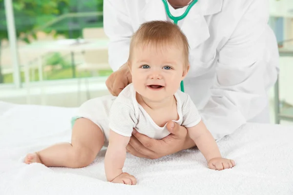 Médico examinando lindo bebé con estetoscopio en el hospital —  Fotos de Stock