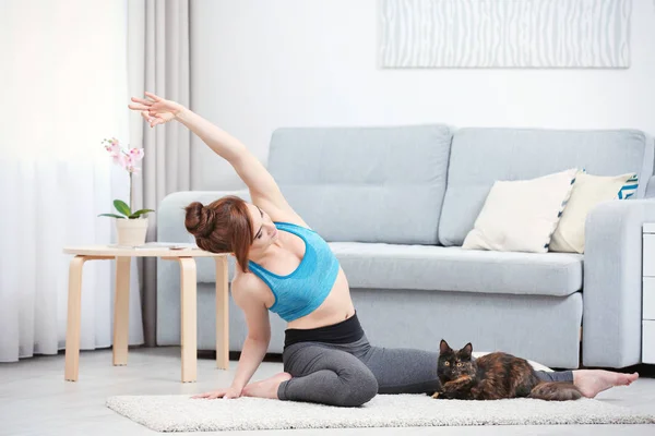 Giovane donna con gatto praticare yoga — Foto Stock