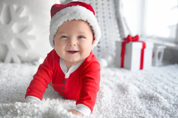 Niedliches kleines Baby mit Weihnachtsmütze auf weichem Stoff — Stockfoto