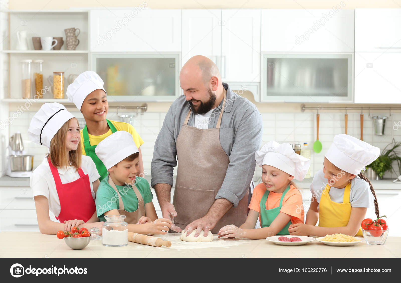 Group of children and teacher in kitchen during cooking classes Stock