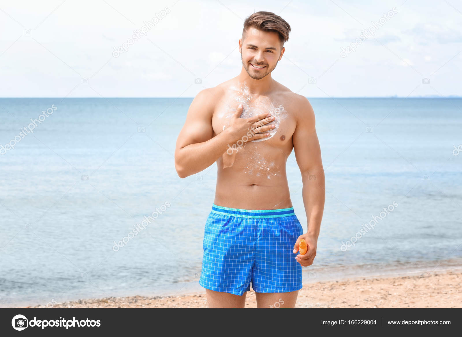 young man applying sunscreen cream — Stock Photo © belchonock 166229004