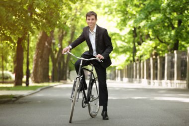 Genç yakışıklı işadamı güneşli günü açık havada bisiklet ile