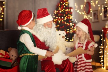 Güzel Noel dekorasyonu ile odada Noel babaya mektuplar gösterilen sevimli elf çocuklar